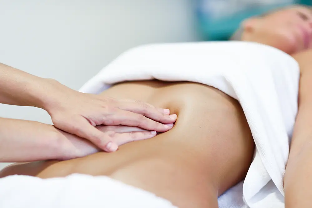 drainage-lymphatique-geneve-hands-massaging-female-abdomen-therapist-applying-pressure-belly